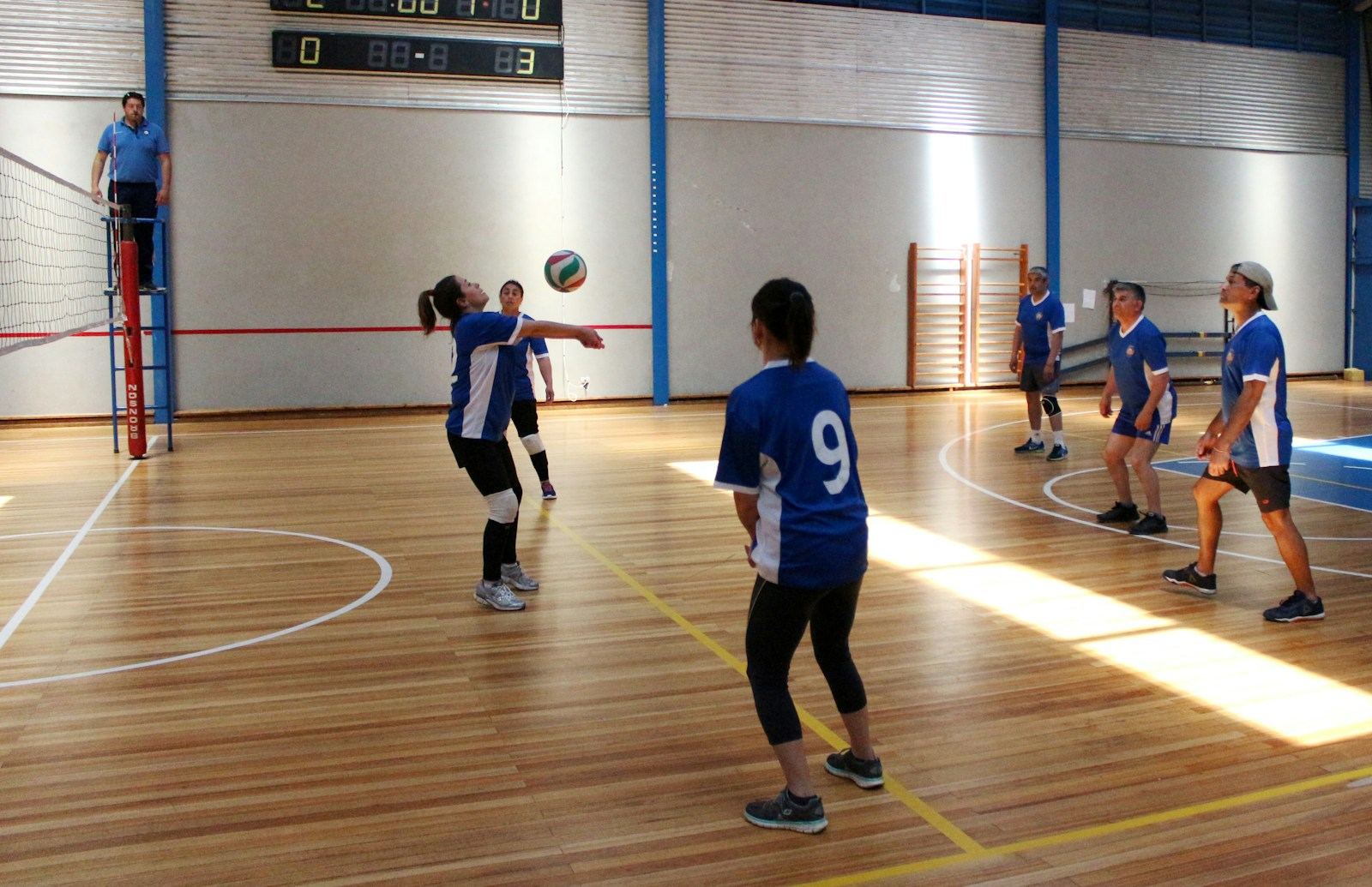 Players running a passing drill on a wooden court