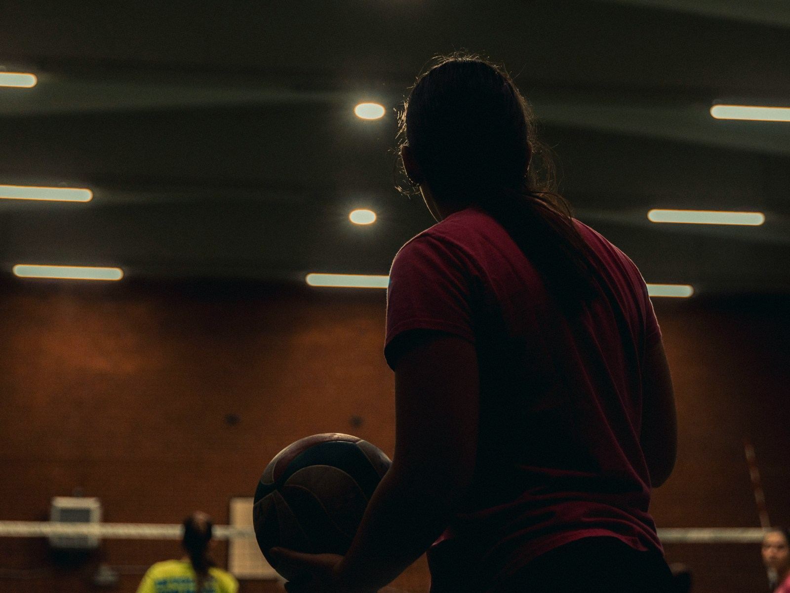 Player holding a ball in a gym
